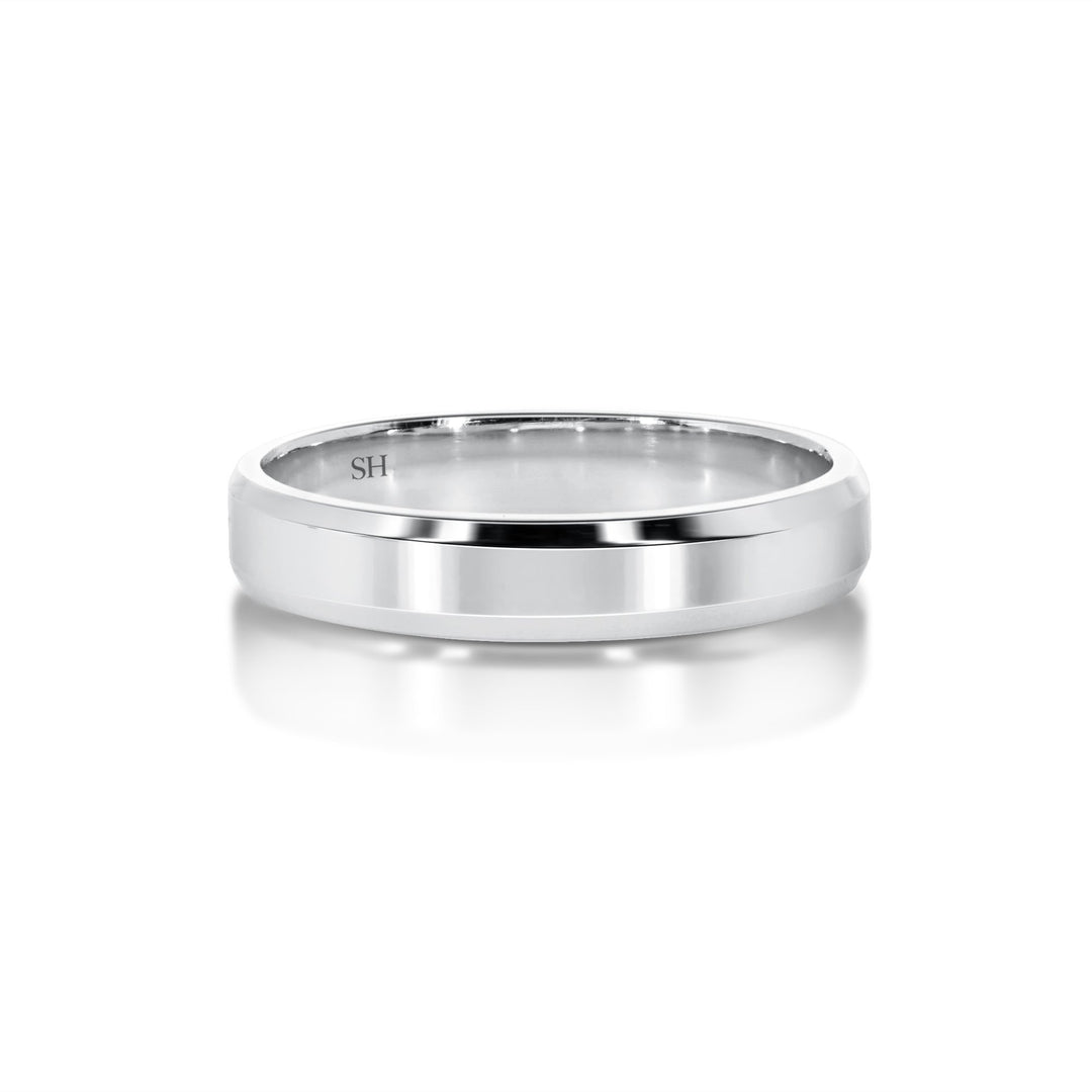 White gold polished finish wedding band with bevelled edges R12-067-W0229. This stylish finer width 18k white gold wedding band has a high polished finish applied to the centre. Faceted beveled edges have been used to catch the light and glitter in a subtle way which adds more charm to an already attractive ring. A modern and captivating look.